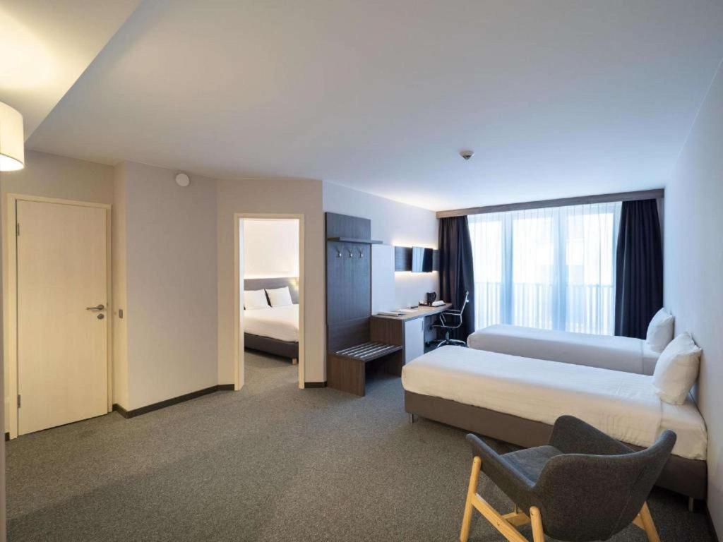 a hotel room with a bed and a desk and a window at Hotel Best Western City Centre in Brussels