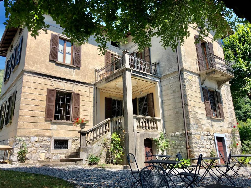 a large building with a balcony and stairs on it at Villa il Maiale Bianco B&B in San Fedele Intelvi