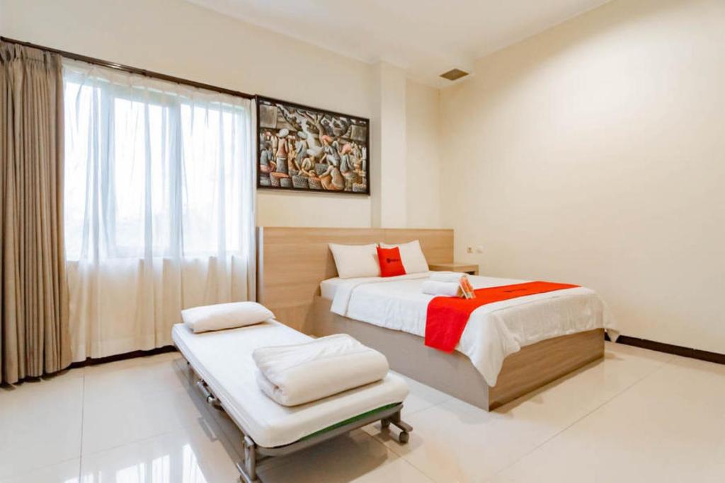1 dormitorio con 2 camas y ventana en RedDoorz near Lembang Park & Zoo 2, en Lembang