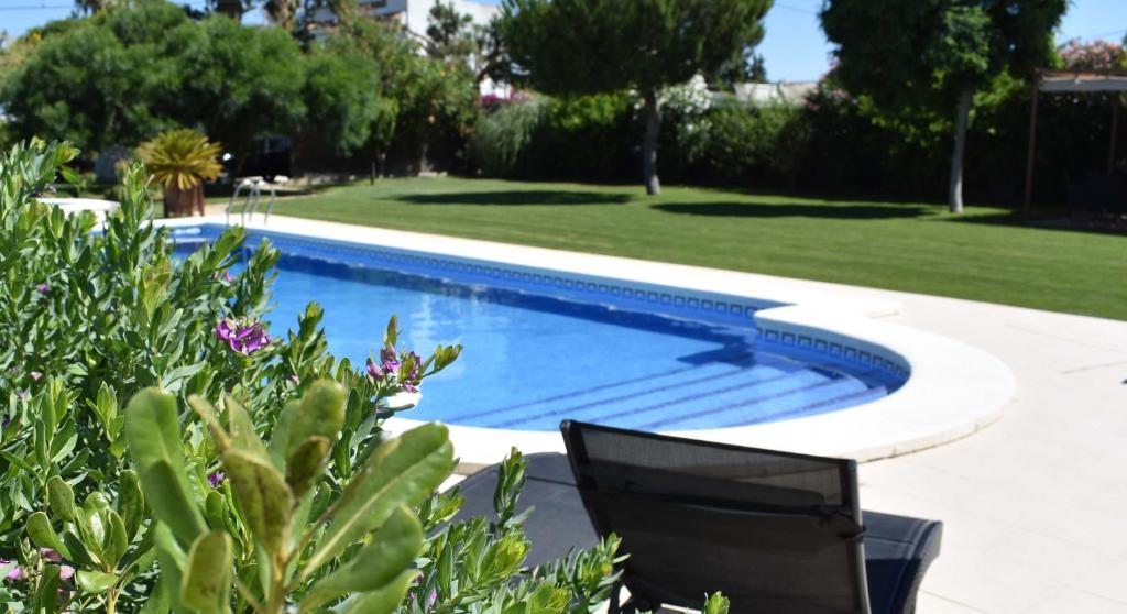 una piscina en un patio con césped en Los Olivos Villa, en Sanlúcar de Barrameda