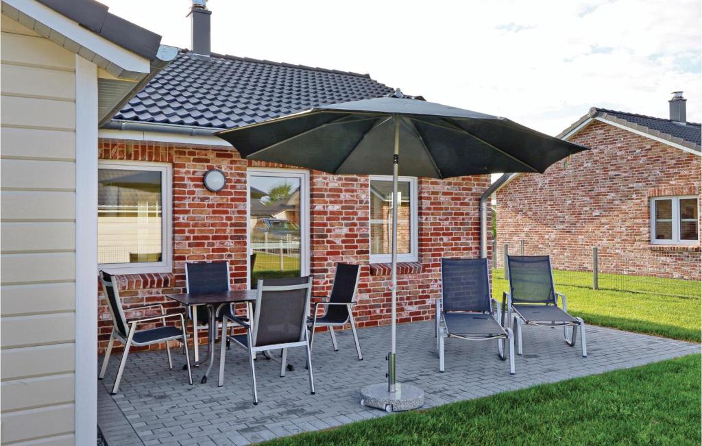 patio con tavolo, sedie e ombrellone di Cozy Home In Dagebll With Wifi a Dagebüll