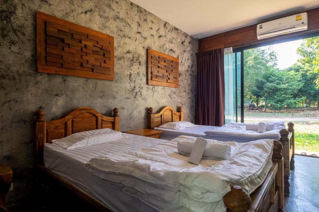 Un pat sau paturi într-o cameră la ชิดธาร รีสอร์ท