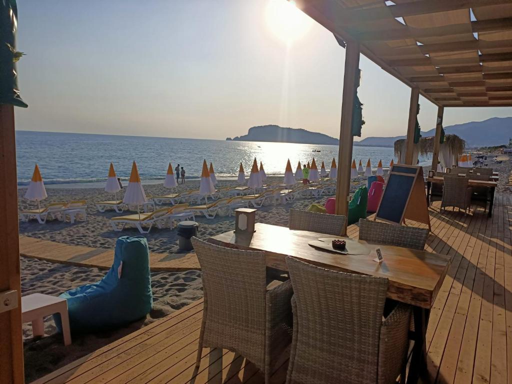 a beach with a table and chairs and the ocean at Bora Bora Butik Hotel in Alanya