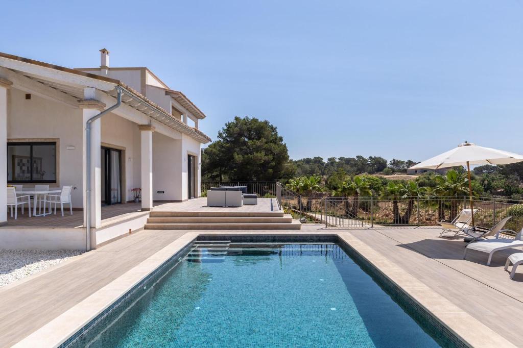 a villa with a swimming pool and a house at Colonies in Ses Salines