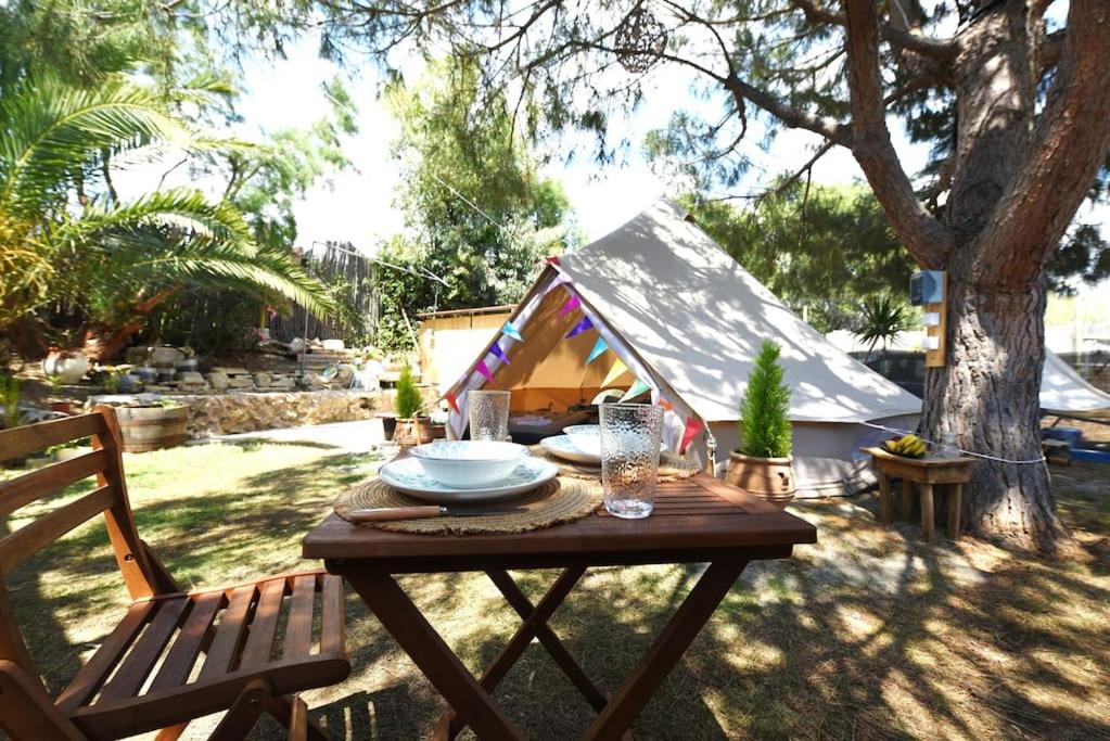 a picnic table in a yard with a dog house at Happy Glamping in Kalamaki Heraklion