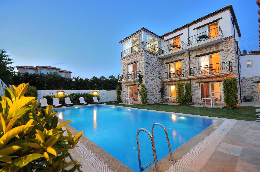 a house with a swimming pool in front of it at Cesme Elysium Hotel in Cesme