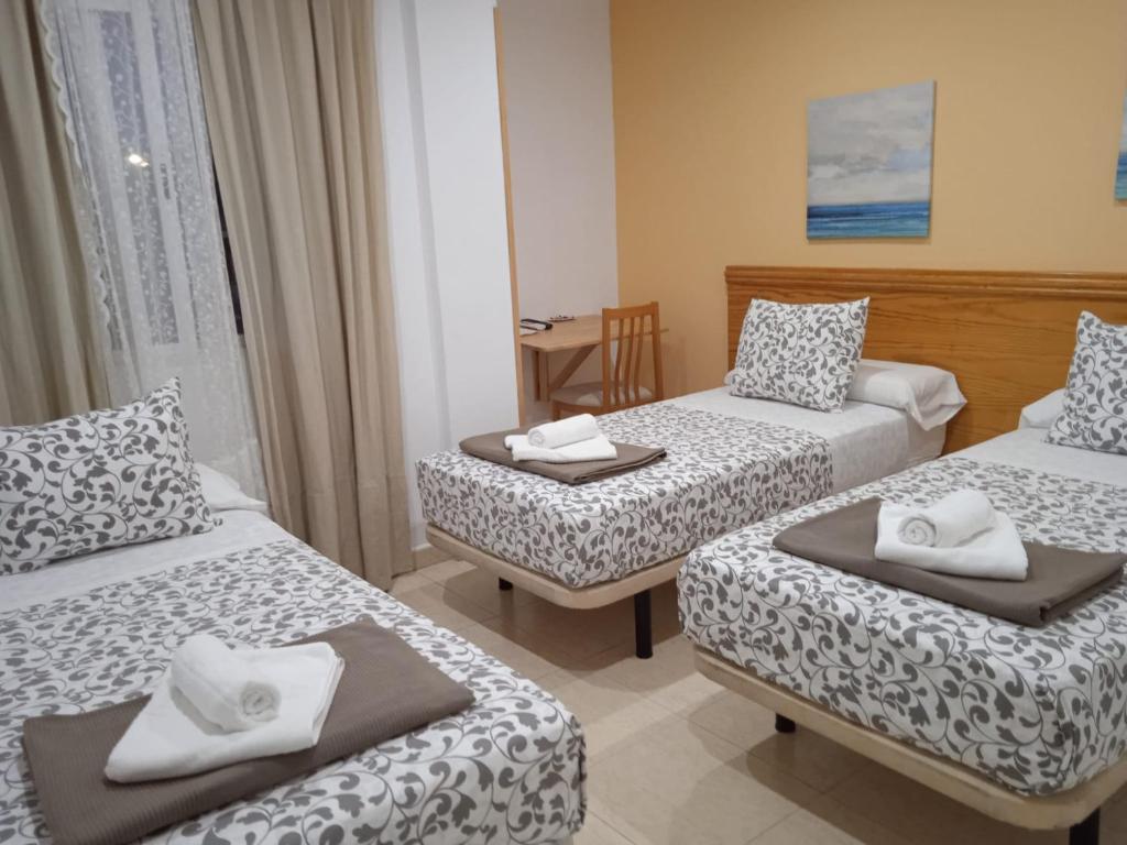 a hotel room with two beds and a table at H El ALAMO MADRID in El Álamo