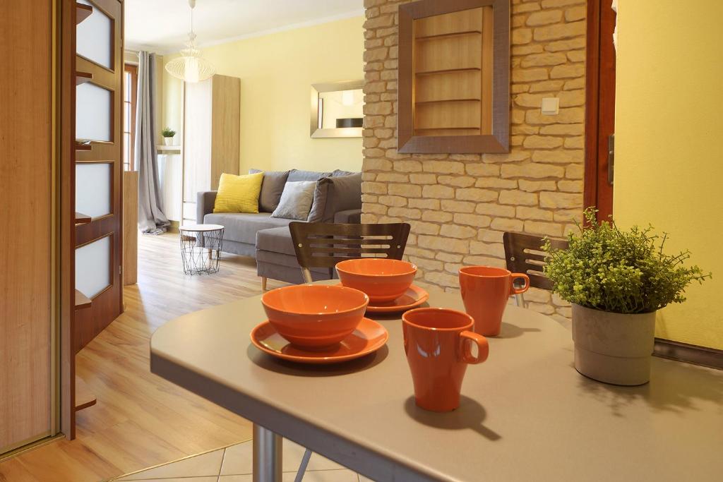 a living room with a table with orange cups on it at Trevilles Ap.- Martynówka in Szklarska Poręba