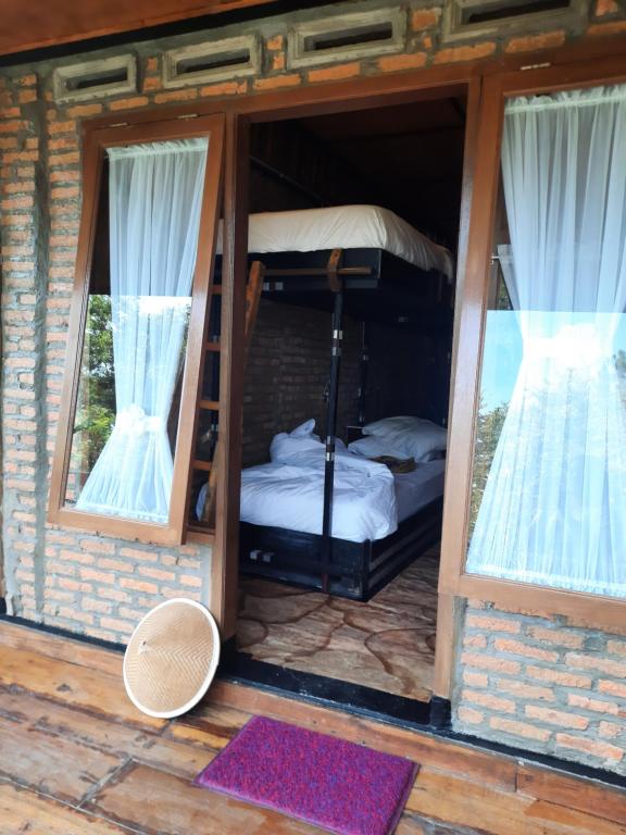 a room with two bunk beds and two windows at The Boat Homestay and Spa in Balige