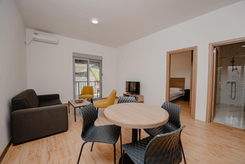 a living room with a table and chairs and a couch at Trsteno Beach Apartments in Budva