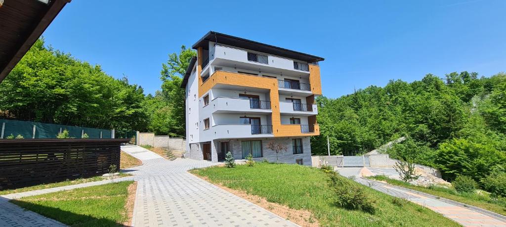 a tall white building on a hill with trees at Maiden Water Resort in Sarajevo