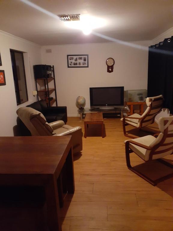 uma sala de estar com cadeiras e uma televisão de ecrã plano em Cartledge Ave house accommodation Whyalla em Whyalla