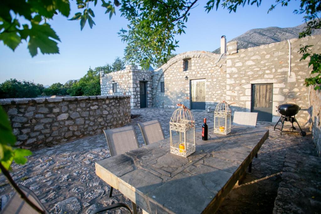 a stone house with a table and chairs and a grill at Mylos villa Mani in Pírgos