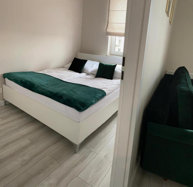 A bed or beds in a room at GREEN APARTMENT SŁONECZNE TARASY
