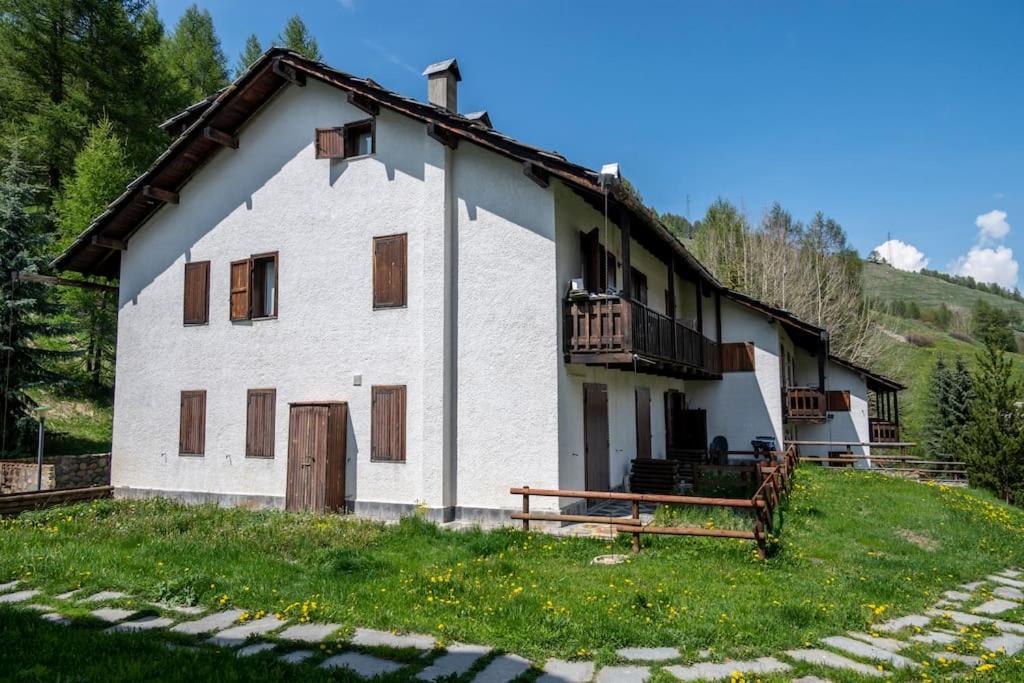 a white house with a porch and a balcony at 037 - Casa Neve e Natura 200 metri impianti sciistici in Borgata Sestriere