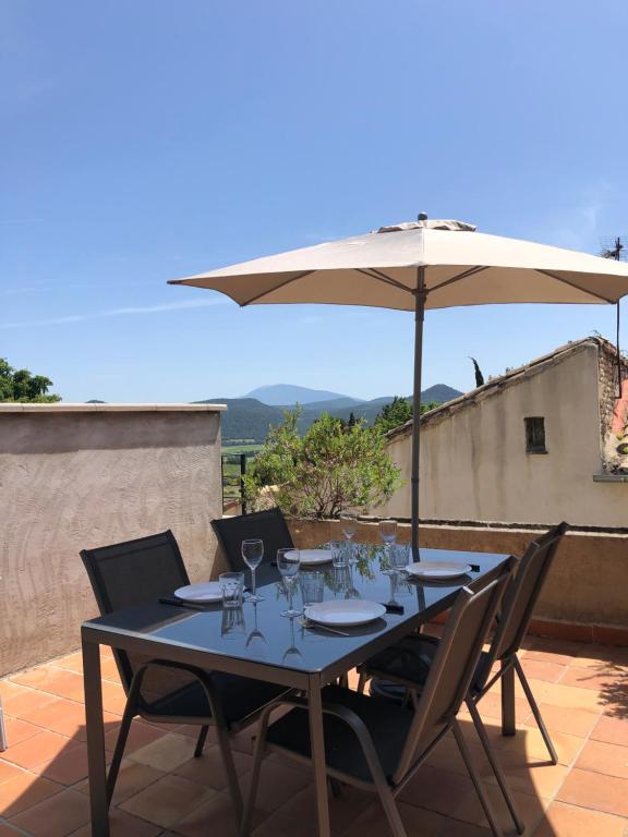 - une table avec un parasol sur la terrasse dans l'établissement Logement au cœur du village de Rasteau, à Rasteau
