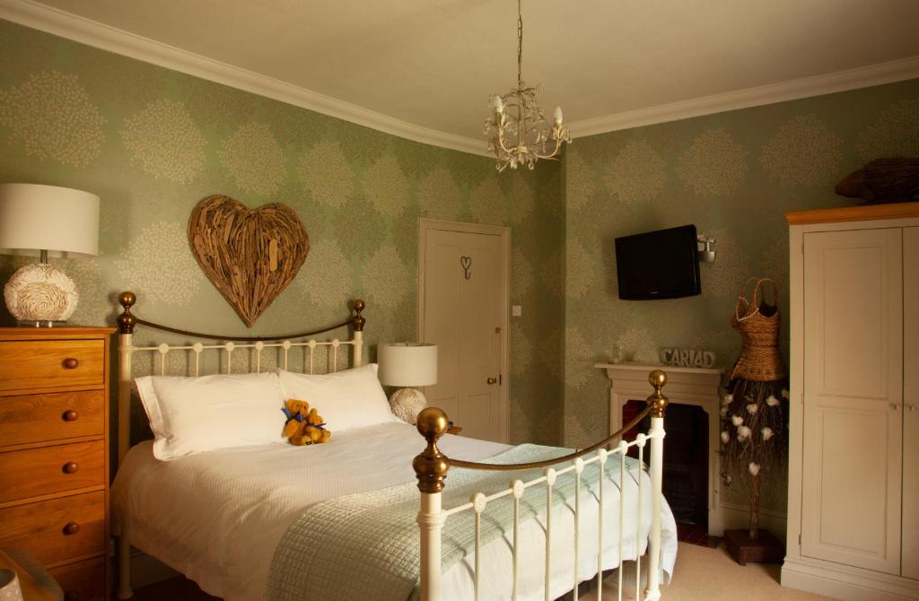 a bedroom with a bed with a heart on the wall at St Katharine's House in Milford Haven