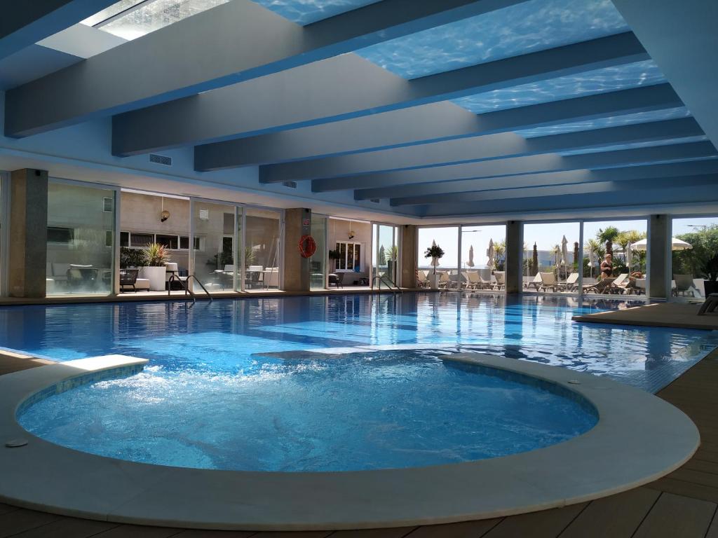 a large pool with blue water in a building at Hotel Covilhã Dona Maria Affiliated by Meliá in Covilhã