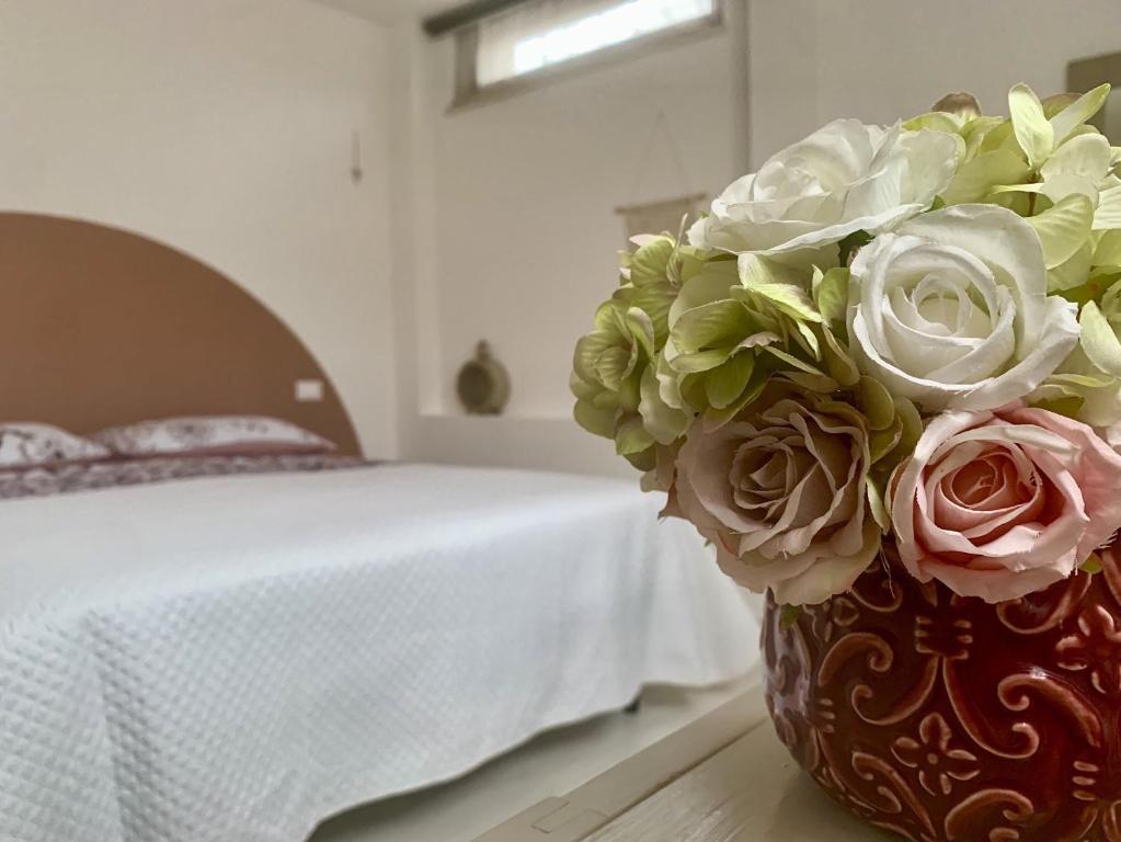 un vaso con un mazzo di fiori in camera da letto di Casa Manila Isola d'Elba a Portoferraio