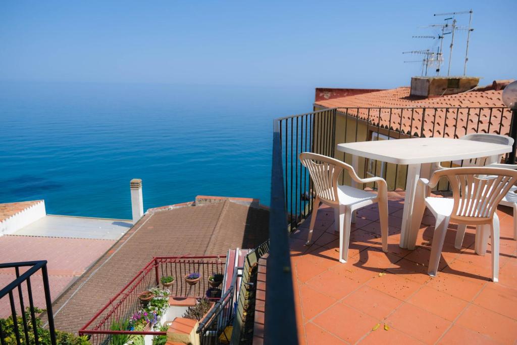 een balkon met een tafel en stoelen en de oceaan bij Appartamenti Giudecca - by Vacation Service in Cefalù