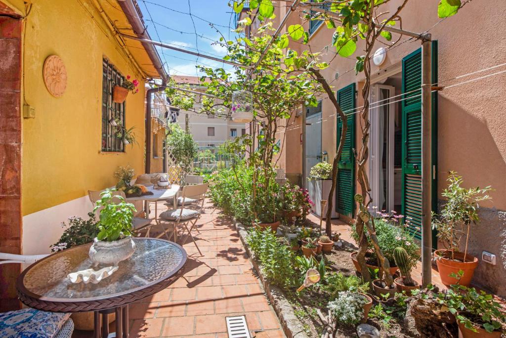 Un patio al aire libre con mesas y plantas en macetas. en Un'oasi al Mare, en Moneglia