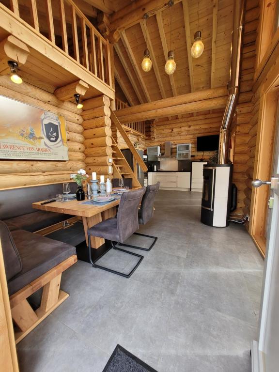 ein Esszimmer mit einem Tisch und Stühlen in einer Hütte in der Unterkunft Blockhaus Waldsee 8 in Rieden