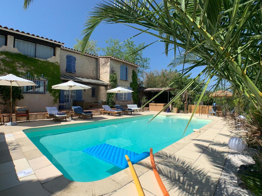 a swimming pool in front of a house at Villa La Rose des Vents in Tourrettes