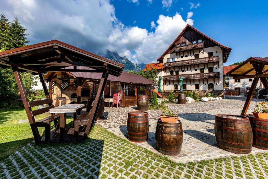 a building with a picnic table and barrels in front of it at Pensiunea Manidum in Buşteni