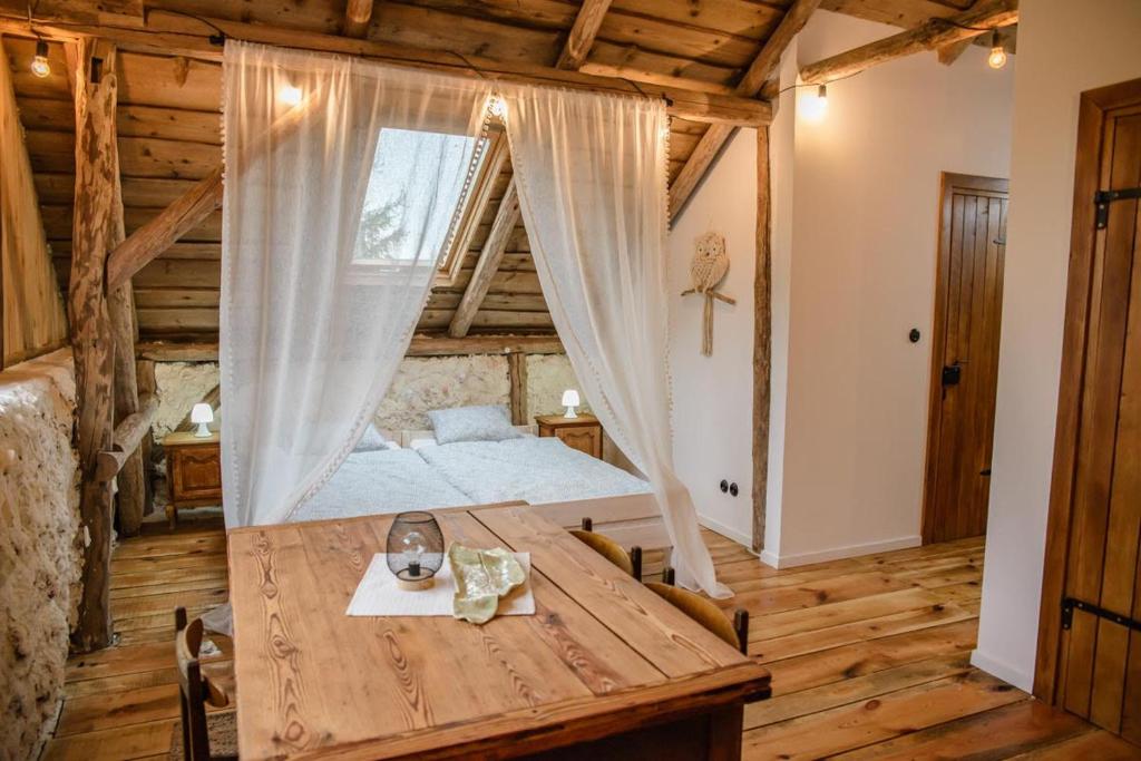 1 dormitorio con cama y mesa de madera en Złota Wójtówka, en Wydminy
