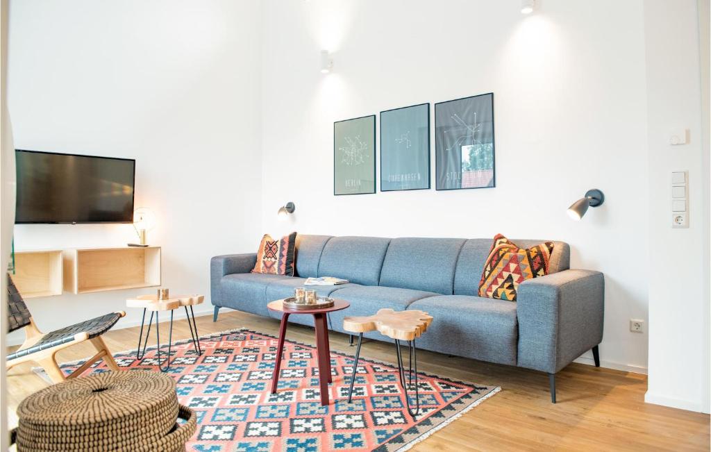 ein Wohnzimmer mit einem blauen Sofa und einem Teppich in der Unterkunft Stunning Home In Lembruch-dmmer See With Sauna in Lembruch