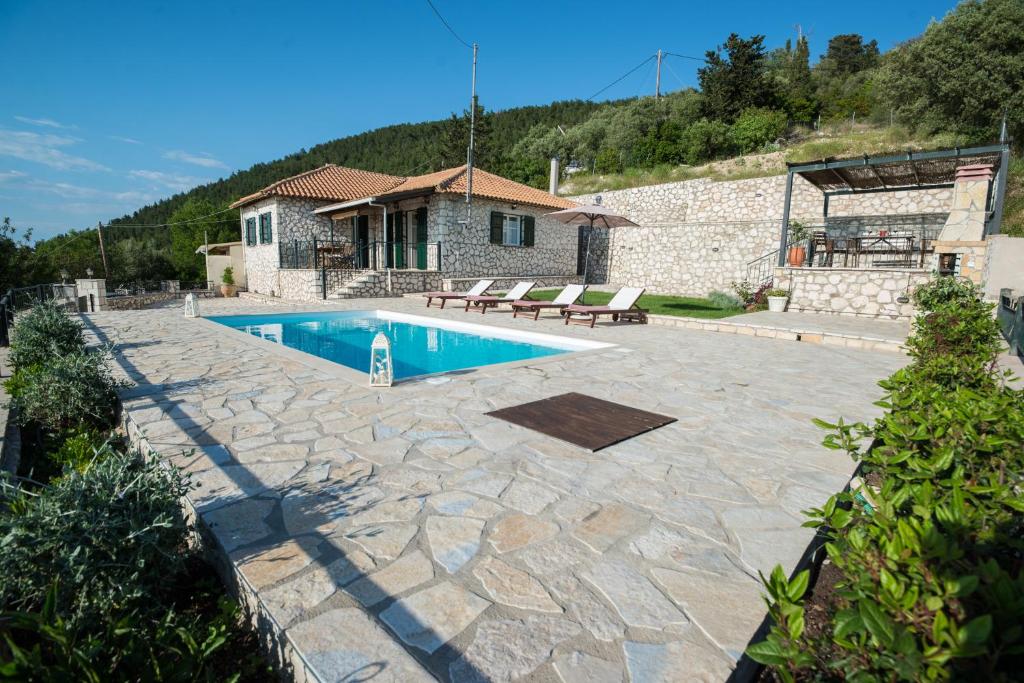 a backyard with a swimming pool and a house at Villa Aurora in Athanion