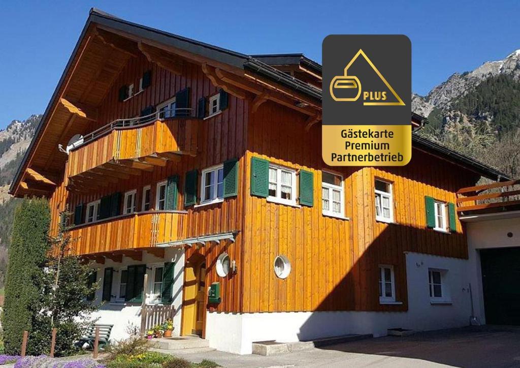 um grande edifício de madeira com uma placa em Ferienwohnung Stelzis em Wald am Arlberg