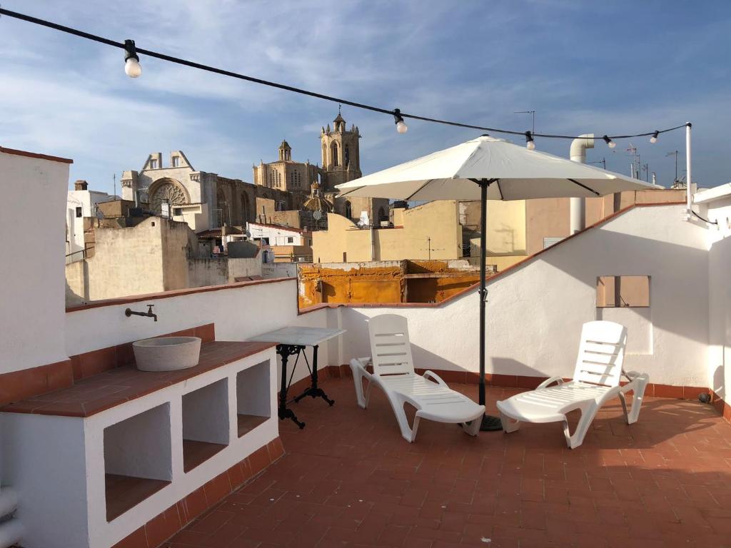 uma varanda com uma mesa e cadeiras e um guarda-sol em Bettatur Apartaments Cuirateries em Tarragona