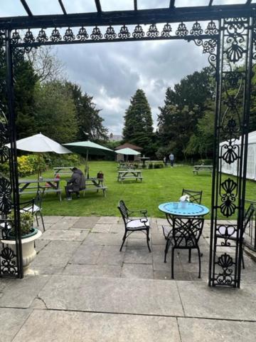 eine Terrasse mit Tisch, Stühlen und Sonnenschirm in der Unterkunft Antrobus Arms Hotel in Amesbury