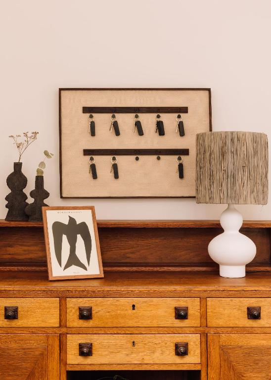 a dresser with a lamp and a picture on it at White Exclusive Suites & Villas in Lagoa