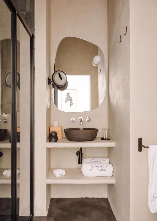 a bathroom with a sink and a mirror at White Exclusive Suites & Villas in Lagoa