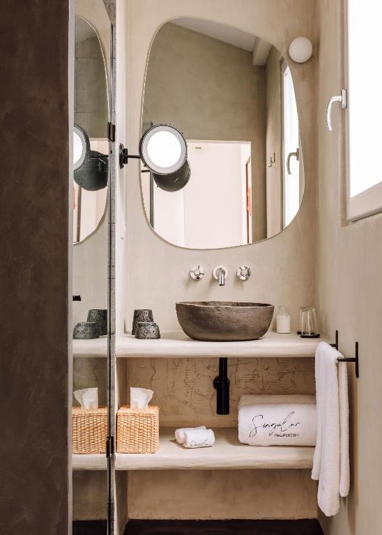 a bathroom with a sink and a mirror at White Exclusive Suites & Villas in Lagoa