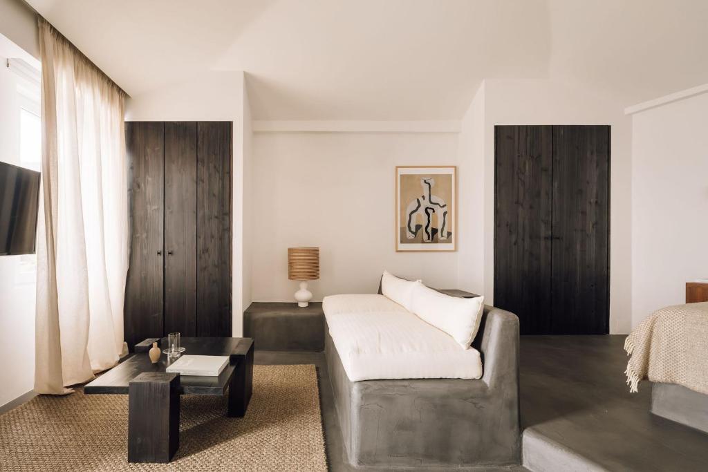a living room with a couch and a bed at White Exclusive Suites & Villas in Lagoa