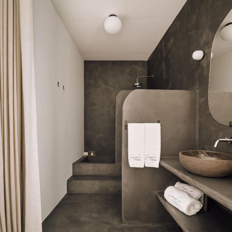 a bathroom with a sink and a stairway with a sink at White Exclusive Suites & Villas in Lagoa