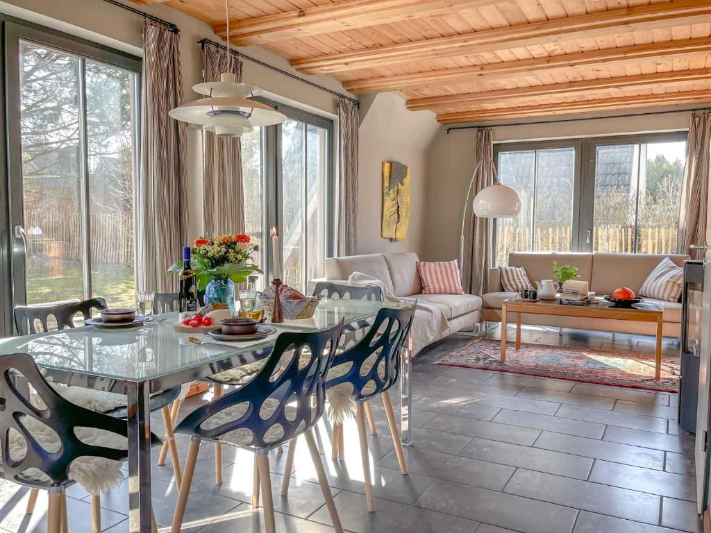 a living room with a table and chairs and a couch at traumHaff - Strandhaus am Achterwasser. Design und Kunst auf Usedom, mit Kamin und Sauna in Quilitz