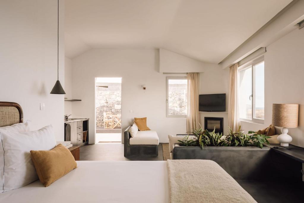 a bedroom with a bed and a living room at White Exclusive Suites & Villas in Lagoa
