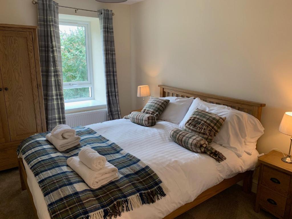 a bedroom with a bed with towels on it at Highland Farm Cottages in Dingwall
