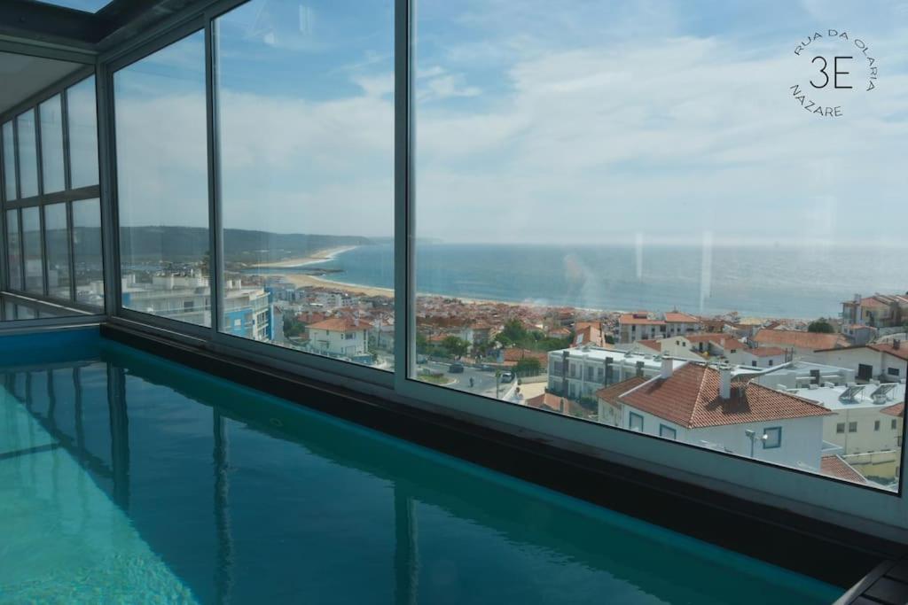 a view of a swimming pool from a building with windows at Rooftop sea view with private swimming pool in Nazaré