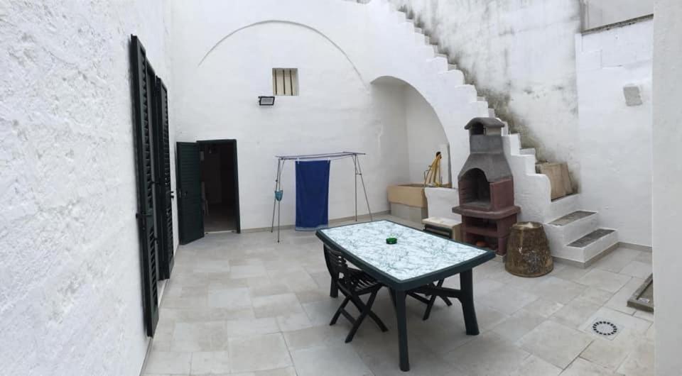 ein Wohnzimmer mit einem Tisch und einem Kamin in der Unterkunft SALENTO - Acquarica del Capo - Lecce in Acquarica del Capo