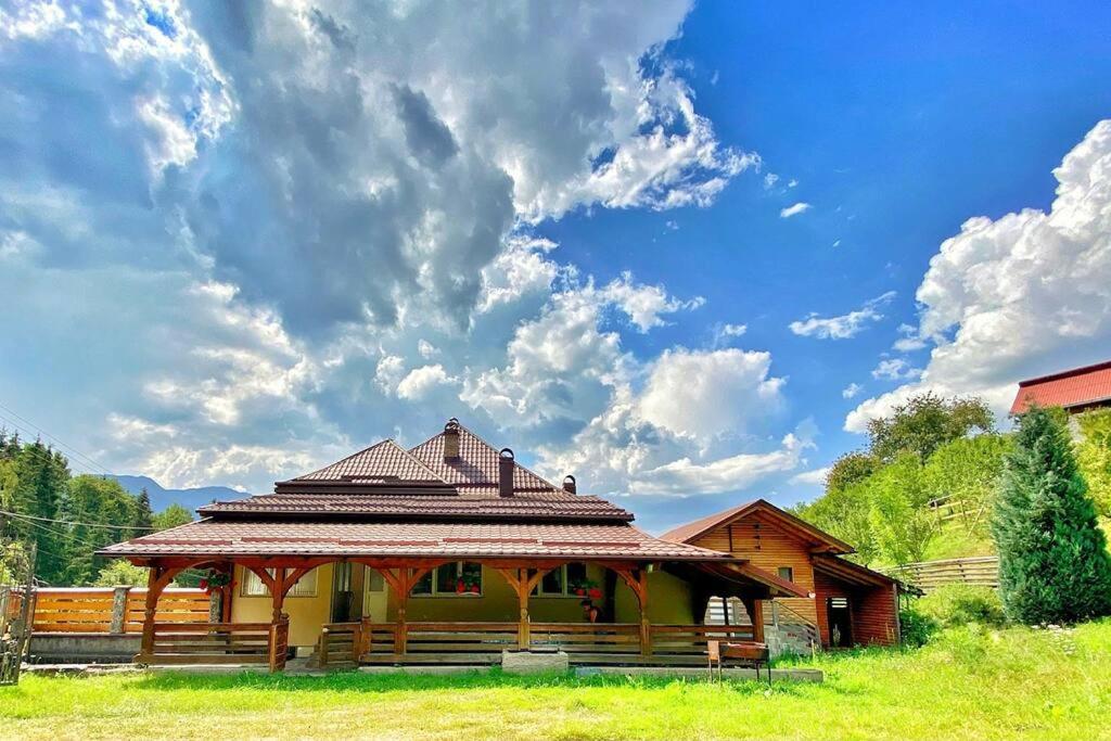 einen Pavillon auf einem Feld mit wolkigem Himmel in der Unterkunft Premium mountain view chalet in Borşa