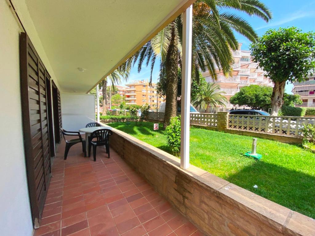 einen Balkon mit einem Tisch und Blick auf das Gras in der Unterkunft Apartamentos Flandria in Salou