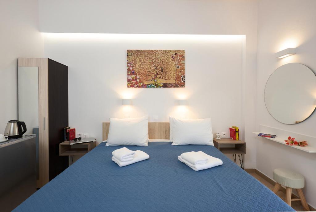 1 dormitorio con 1 cama azul y 2 toallas blancas en Afroditi Hotel en Plakias