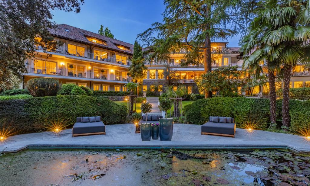梅拉諾的住宿－Villa Eden a member of Leading Hotels of the World，享有带庭院的建筑外部景色