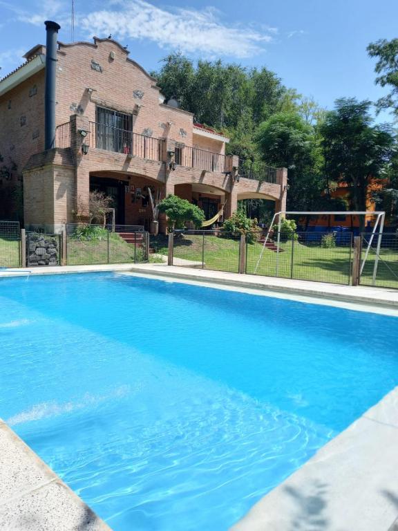 a large blue swimming pool in front of a house at La Mexicana - Alta Gracia in Alta Gracia