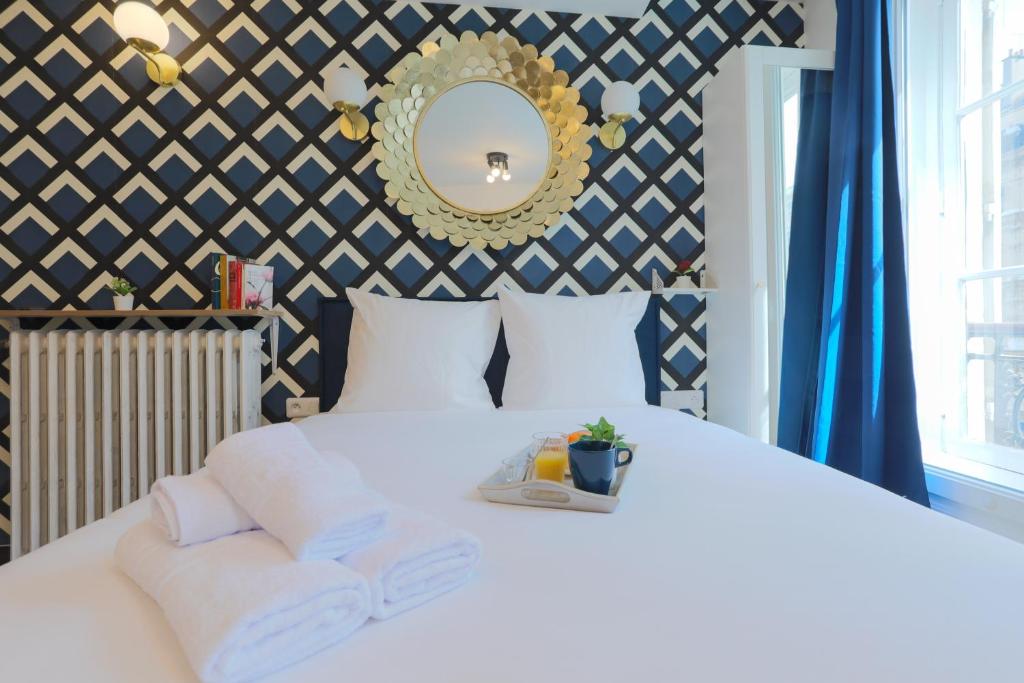 1 dormitorio con cama blanca y espejo en Apartments WS Notre-Dame - Linné en París